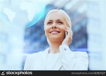 business, technology and people concept - smiling businesswoman with smartphone and globe hologram talking over office building