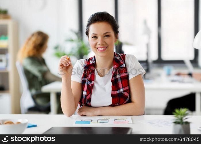 business, technology and people concept - smiling creative woman or developer working on user interface design at office. creative woman working on user interface at office. creative woman working on user interface at office