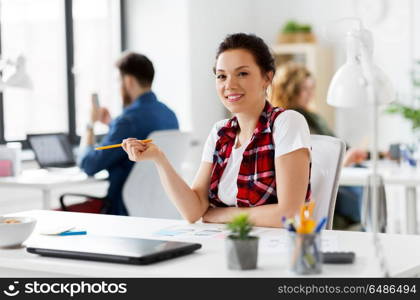 business, technology and people concept - smiling creative woman or developer working on user interface design at office. creative woman working on user interface at office. creative woman working on user interface at office