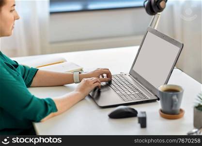 business, technology and people concept - woman with laptop computer working at home office. woman with laptop working at home office