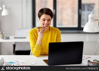 business, technology and ui design concept - smiling female designer with laptop computer and user interface templates using voice command recorder on smartphone at office. designer recording voice by smartphone at office