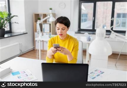 business, technology and user interface design concept - ui designer with templates using smartphone at office. ui designer using smartphone at office