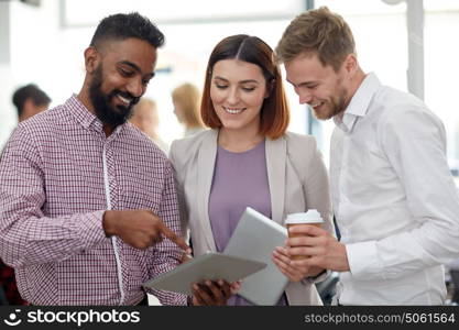 business, technology, break and people concept - happy international creative team with tablet pc computer drinking coffee and talking at office. business team with tablet pc and coffee at office