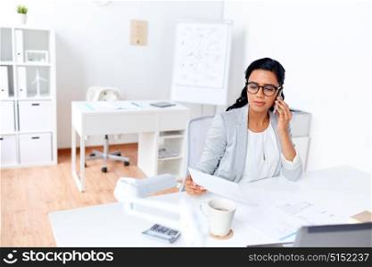 business, technology, communication and people concept - businesswoman with papers calling on smartphone at office. businesswoman calling on smartphone at office