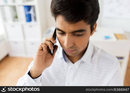 business, technology, communication and people concept - close up of businessman calling on smartphone at office. businessman calling on smartphone at office