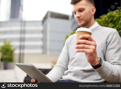 business, technology, communication and people concept - close up of man with tablet pc computer drinking coffee from paper cup and sitting on city street