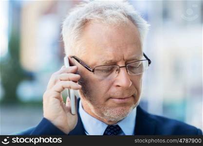 business, technology, communication and people concept - close up of senior businessman calling on smartphone in city