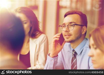 business, technology, communication and people concept - happy businessman calling on smartphone at office. businessman calling on smartphone at office