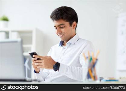 business, technology, communication and people concept - happy businessman with smartphone at office. happy businessman with smartphone at office