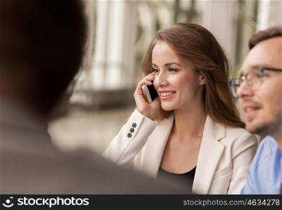 business, technology, communication and people concept - happy businesswoman calling on smartphone at office