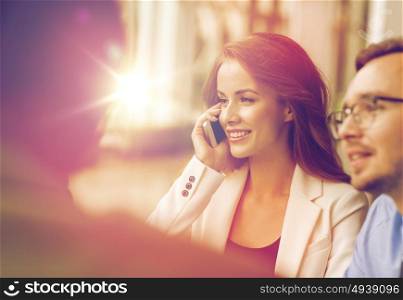 business, technology, communication and people concept - happy businesswoman calling on smartphone at office. businesswoman calling on smartphone at office