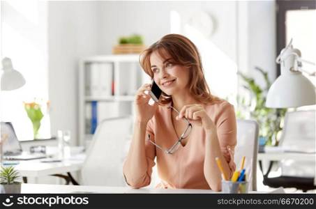 business, technology, communication and people concept - happy businesswoman calling on smartphone at office. businesswoman calling on smartphone at office. businesswoman calling on smartphone at office