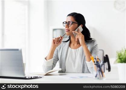 business, technology, communication and people concept - happy businesswoman or secretary with notebook calling on smartphone at office. businesswoman calling on smartphone at office