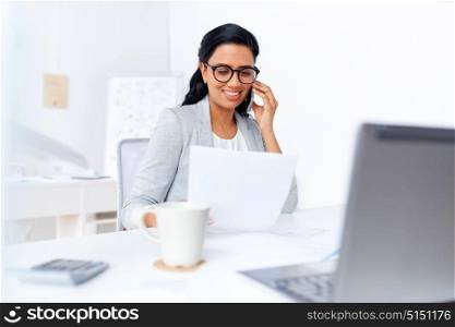 business, technology, communication and people concept - happy businesswoman with papers calling on smartphone at office. businesswoman calling on smartphone at office
