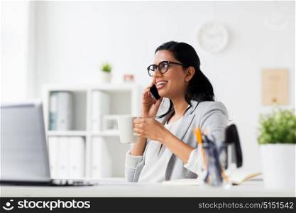 business, technology, communication and people concept - happy smiling businesswoman or secretary calling on smartphone and drinking coffee at office. businesswoman calling on smartphone at office