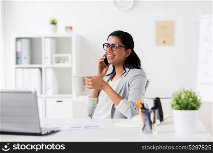 business, technology, communication and people concept - happy smiling businesswoman or secretary calling on smartphone and drinking coffee at office. businesswoman calling on smartphone at office