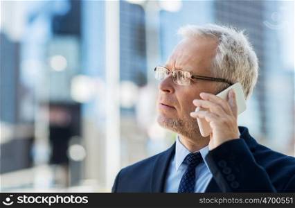 business, technology, communication and people concept - senior businessman calling on smartphone in city