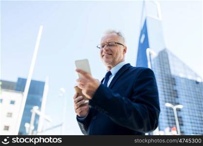 business, technology, communication and people concept - senior businessman with coffee cup and smartphone in city