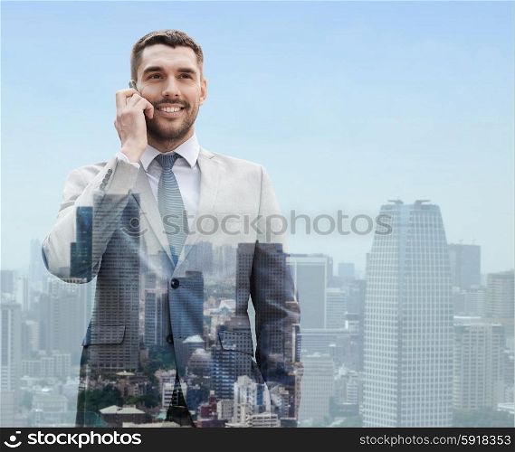 business, technology, communication and people concept - smiling businessman with smartphone talking over city background