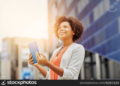 business, technology, communication and people concept - young smiling african american businesswoman with tablet pc computer in city