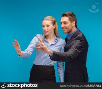business, technology, communication concept - businesswoman and businessman working with imaginary virtual screen