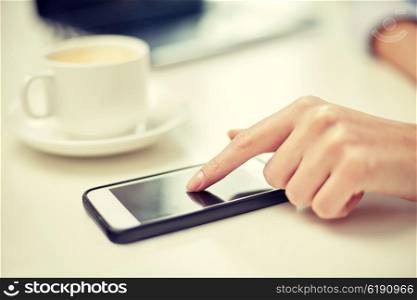 business, technology, communication, leisure and people concept - close up of woman hand with smartphone and coffee