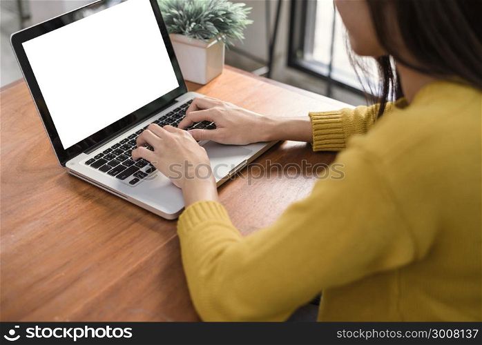 Business Technology Concepts - Digital lifestyle working outside office. Woman hands typing laptop computer with blank screen on table in coffee shop. Blank laptop screen mock up for display of design