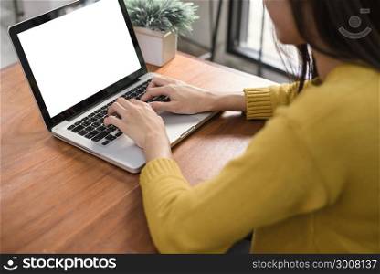 Business Technology Concepts - Digital lifestyle working outside office. Woman hands typing laptop computer with blank screen on table in coffee shop. Blank laptop screen mock up for display of design