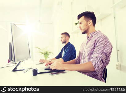 business, technology, design and people concept - young creative man or designer with computer and pen tablet working at office. man or designer with computer and tablet at office