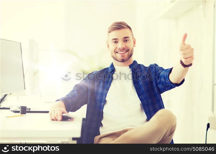 business, technology, education and people concept - happy young creative man or student with computer at office at office showing thumbs up. happy creative man with computer at office. happy creative man with computer at office