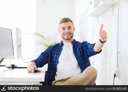 business, technology, education and people concept - happy young creative man or student with computer at office at office showing thumbs up