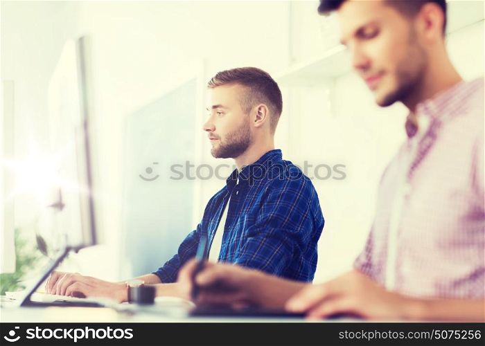 business, technology, education and people concept - young creative man or designer with computer at office. creative man or student with computer at office