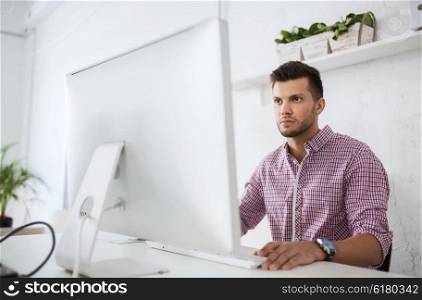business, technology, education and people concept - young creative man or student with computer at office