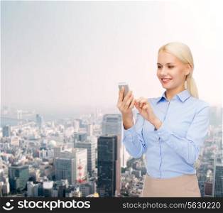 business, technology, estate and people concept - smiling young businesswoman with smartphone over cityscape background