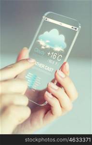 business, technology, forecast and people concept - close up of woman hand holding and showing transparent smartphone with weather cast on screen