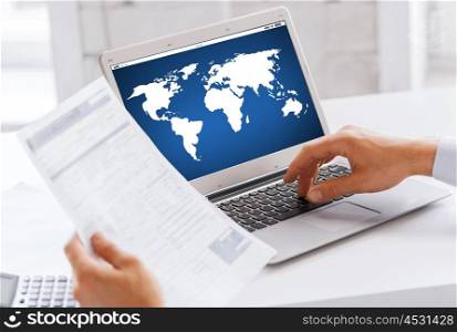 business, technology, global communication, network and people concept - close up of businessman with world map on laptop computer screen working at office