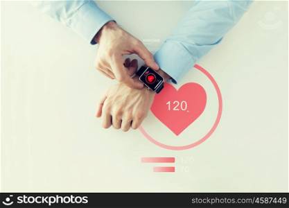 business, technology, health care, application and people concept - close up of male hands setting smart watch with red heart icon screen