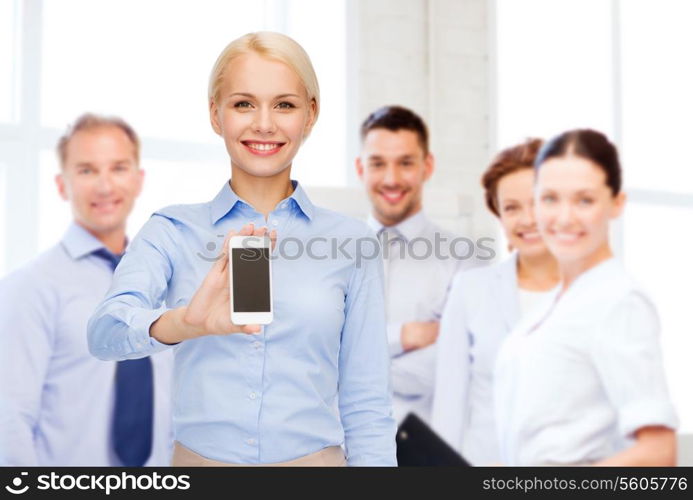 business, technology, internet and education concept - friendly young smiling businesswoman with smartphone blank screen