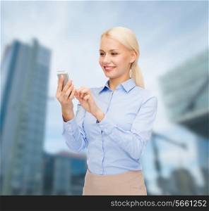 business, technology, internet and education concept - smiling young businesswoman with smartphone over business centre background