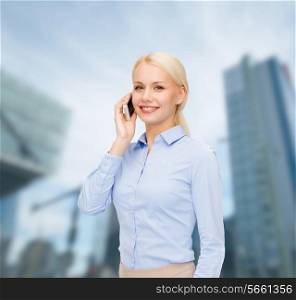 business, technology, internet and education concept - smiling young businesswoman with smartphone over business centre background