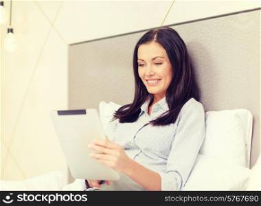 business, technology, internet and hotel concept - happy businesswoman with tablet pc computer lying in hotel in bed