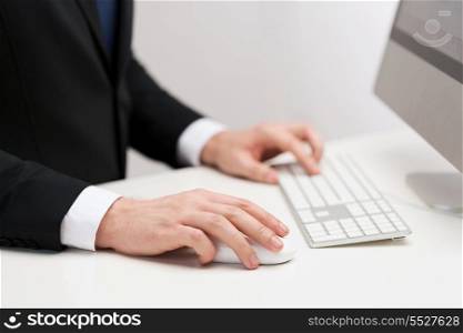 business, technology, internet and office concept - close up of businessman hands working with keyboard and mouse