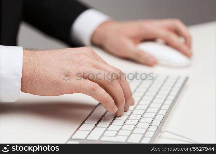 business, technology, internet and office concept - close up of businessman hands working with keyboard and mouse