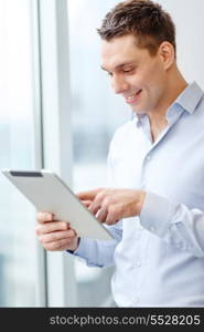 business, technology, internet and office concept - smiling businessman with tablet pc computer in office