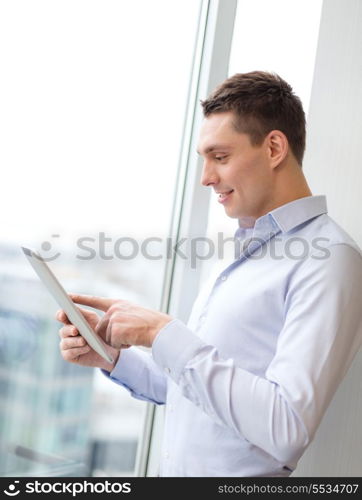 business, technology, internet and office concept - smiling businessman with tablet pc computer in office