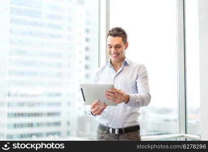 business, technology, internet and office concept - smiling businessman with tablet pc computer in office