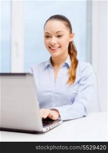 business, technology, internet and office concept - smiling businesswoman with laptop in office