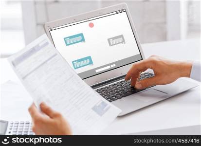business, technology, internet, online communication and people concept - close up of businessman with messenger on laptop computer screen working at office