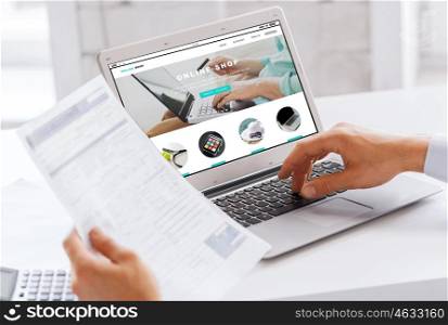 business, technology, internet shopping and people concept - close up of businessman with online shop web page on laptop computer screen working at office