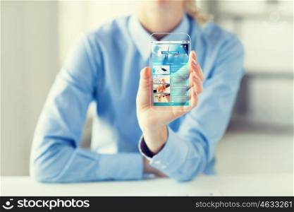 business, technology, mass media, internet and people concept - close up of woman hand holding and showing news web page on transparent smartphone screen at office